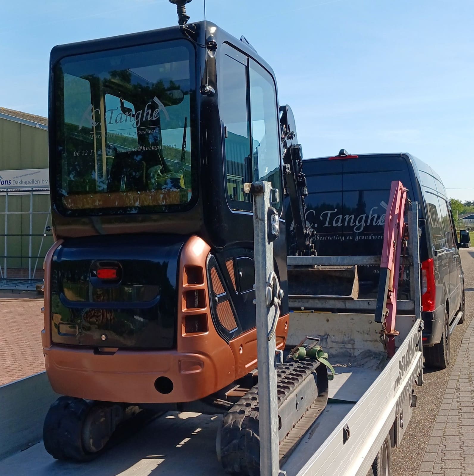 Minigraver op een aanhanger achter de bus