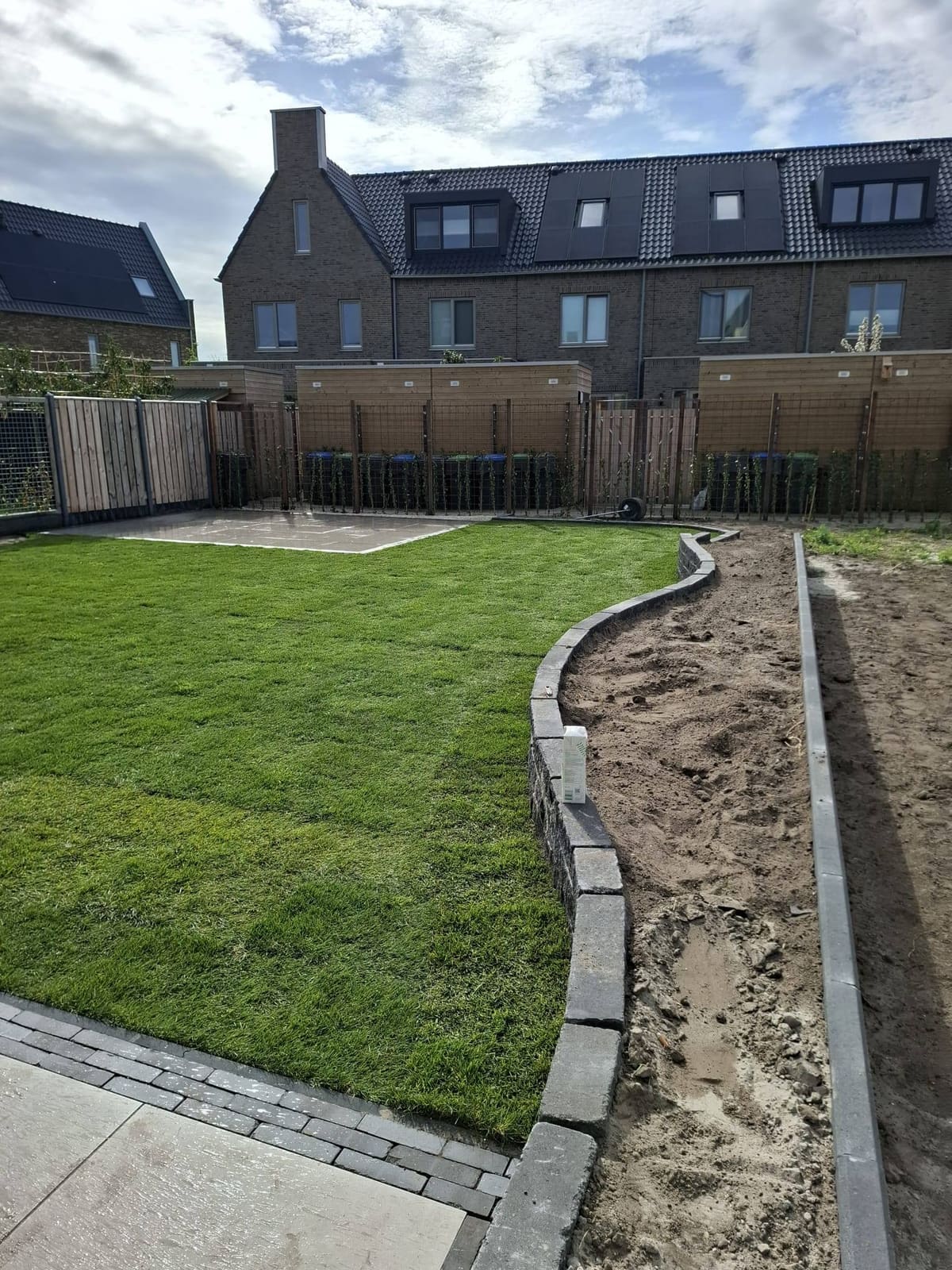 Vers gelegde graszoden met opsluitbanden en een rand langs een nieuwbouwtuin